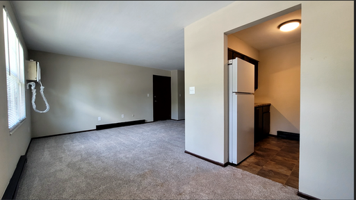 Carpeted living room open to kitchen