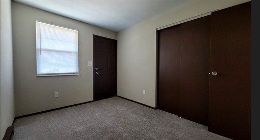 Carpeted bedroom with large closet