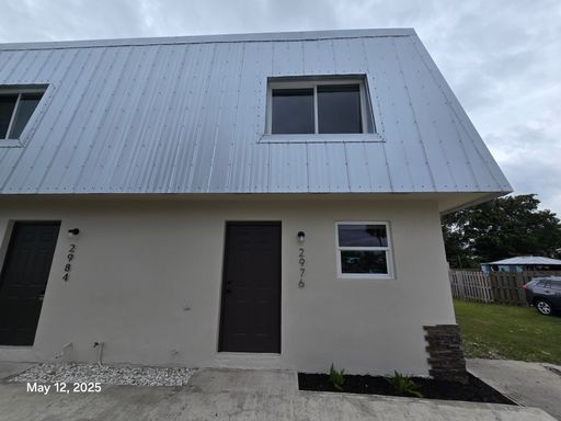 This renovated home provides modern convenience with a durable metal roof, impact-resistant windows, and brand-new carpeting throughout. – photo 1