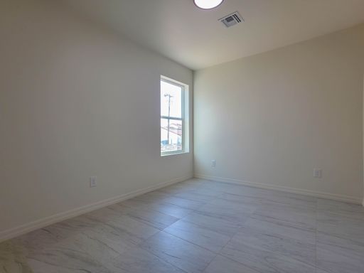 Unit 1 bedroom with a tall window.