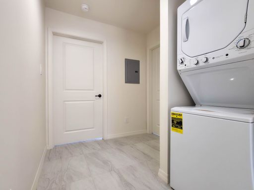 Unit 3 stacked washer and dryer beside an interior hallway.